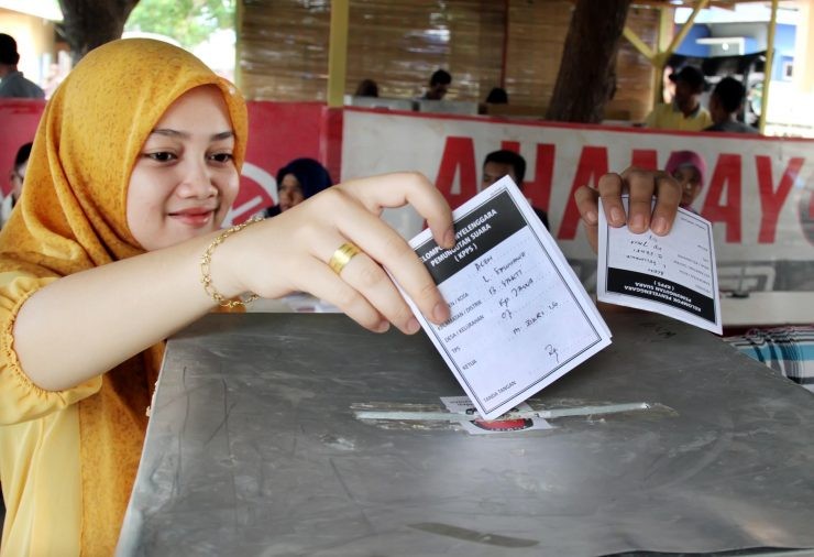 Ilustrasi warga memasukkan kertas surat suara ke kotak suara pada pemilihan umum di Lhokseumawe, Aceh - nalar.id